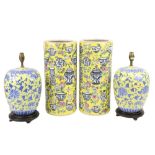A pair of Chinese yellow ground porcelain Stick Stands, decorated with flowers, bowls, vases and