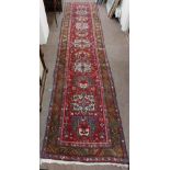 A fine quality Middle Eastern woollen Runner, the central red ground with five medallions, inside