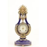 A dark blue porcelain and parcel gilt lyre shaped Clock, with crystal bezel and mask crest after