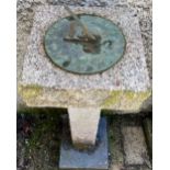 A modern carved granite Pedestal, with square top with circular bronze sundial with gnomon,