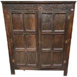 A 19th Century carved oak Cupboard or Wardrobe, the frieze with a series of S scrolls over two