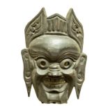 A carved Chinese wooden Mask, with open mouth and eyes, 24cms (9 1/2"). (1)