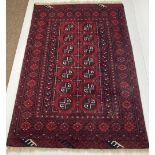 A heavy woollen Rug, the overall burgundy ground with 14 medallions and multiple borders, approx.