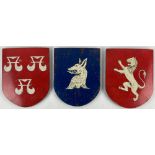A set of 3 shield shaped painted mahogany Panels, all with different crest, 24cms (9 1/2"). (3)