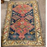 A semi-antique woollen Rug, with blue ground central panel and two large red medallions, within a