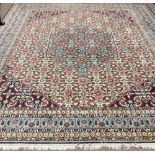 An attractive and large Indian woolen Carpet, the central panel of flowers on plain blue ground,