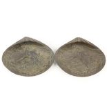 A pair of bronzed and silvered Chinese shell shaped Dishes, each chased with a dragon circling a