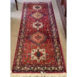 An attractive Middle Eastern red ground Carpet, with five colourful medallions, and multiple