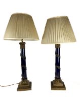 An attractive pair of brass mounted and ebonised Table Lamps, each with a brass Doric capital and