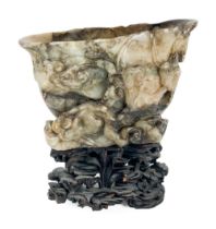 A heavy Chinese carved hard stone Libation Cup, on fitted carved cherry stand, 15cms (6"). (1)