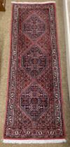 A Middle Eastern pink ground small Rug, the centre with three navy ground floral medallions,