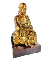 A Chinese gilt and bronzed cast metal Figure, of a seated Buddha on associated wooden base, 19cms (7
