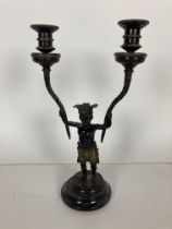 A bronze Candelabrum, modelled as an Aboriginal Young Man holding two spiral reeded candle arms,