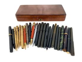 An unusual Collection of approx. 25 various Fountain Pens, Pencils, in rectangular mahogany box. (1)