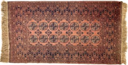 A large rust ground Bokhara Rug, with two rows of octagons inside a multi border, 194cms x 110cms (