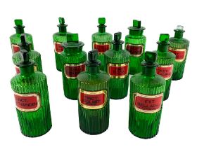 A collection of 12 rare reeded and green coloured Apothecary Bottles, with lids, with painted labels