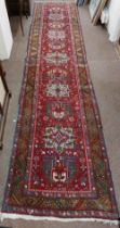 A fine quality Middle Eastern woollen Runner, the central red ground with five medallions, inside