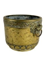 A heavy Chinese brass Brush Pot, with two grotesque temple lion masks with ring suspenders, the edge