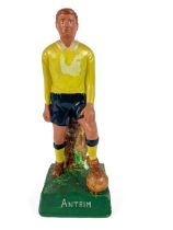 G.A.A.: a hand painted plaster Figure of a Footballer "Antrim,"  in standing position with foot on
