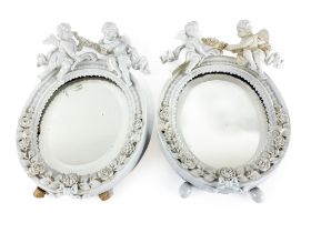 A pair of oval blanc-de-chine Dresden porcelain Table Mirrors, flower encrusted and crested with two