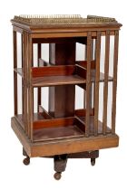 An Edwardian mahogany square Revolving Bookcase, with four brass galleries and slatted sides,