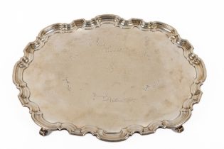 A large heavy oval silver Tray, with shaped pie crust edge on four scroll legs by Atkin Brothers,