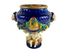 A Majolica Jardinière, of urn form the multi coloured ground moulded in high relief with ram head