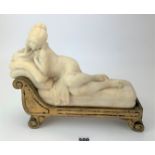 Alabaster figure of reclining lady on wooden chaise longue
