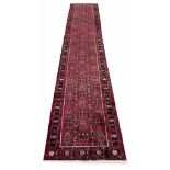 Persian runner, with floral pattern on a red ground, 162" x 33"