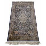 Indian silk rug, with central medallion on a blue ground within foliate repeated borders, 73" x 42"