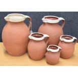 Graduated set of four Royal Barum Ware terracotta jugs, largest 9.5" high; together with a larger