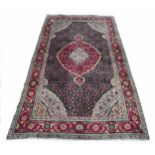 Persian Tabriz pattern rug, on a deep red ground, 115" x 78"