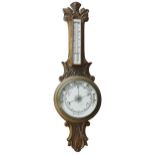 Oak aneroid barometer/thermometer, the 8" principal cream dial within a foliate carved case, 33"