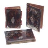 Two Victorian tortoiseshell and piqué decorated pocket notebooks and a card case, each with