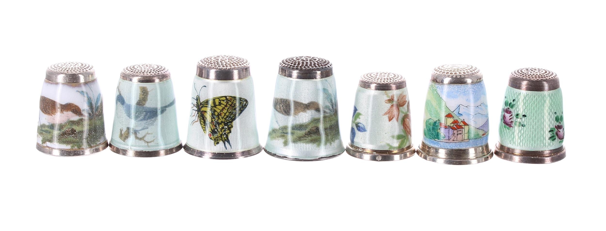 Collection of seven modern silver and guilloché enamel thimbles, detailing birds, a butterfly,