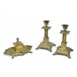 Pair of ornate repoussé brass candlesticks, with corinthian column supports over squared bases