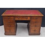 Victorian oak pedestal desk, the top with a red leather inset, over nine drawers to the kneehole