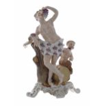 Sitzendorf porcelain figural group of Bacchus, modelled leaning against a tree trunk eating