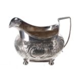 George III boat shaped silver cream jug, with a reeded handle and repousse decorated scroll and