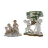 19th century Berlin KPM porcelain figural group of two putti, modelled seated reading plans and with