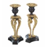 Pair of 19th century French Empire parcel gilt patinated bronze candlesticks, raised on three