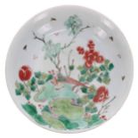 Chinese famille verte porcelain circular shallow bowl, decorated with a bird admist a garden