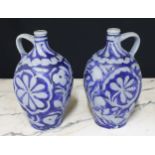 Pair of German stoneware flasks, with inscribed and blue stylised floral decorations on a grey