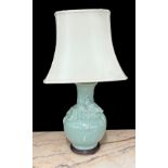 Chinese celadon glaze porcelain table lamp, decorated in relief with a dragon, with shade, the