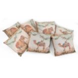 Seven decorative cushions, five decorated with elephants in Indian processional dress, within