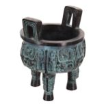 Chinese twin-handled cast bronze tripod censor, with carved archaic style decoration, the interior