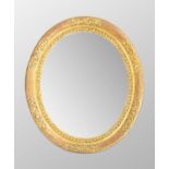 Large antique gilt wood and gesso oval wall mirror, with a moulded floral frame, 38" x 32"