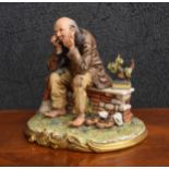Capodimonte Tramp porcelain figure, modelled seated on a stone wall, factory inscriptions to the