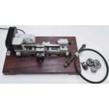 Unimat Emico electric lathe with attachments, fitted onto a mahogany plinth, 20" long, 12" wide