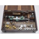 Small watchmakers lathe, within a fitted wooden case with various collets and other attachments (